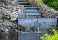 Decorative artificial waterfall in summer park. Royalty Free Stock Photo