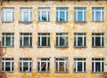 Decorative background - wall, windows. The photo shows the orange wall of the old school and many windows, in one of which a toy