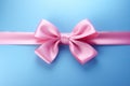 Decorative beautiful pink satin ribbon with bow for decorate gift box or greeting card on light blue background. Royalty Free Stock Photo