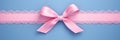 Decorative beautiful pink satin ribbon with bow for decorate gift box or greeting card on light blue background Royalty Free Stock Photo