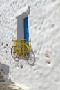 Decorative bicycle hanging from a window in a Greek house