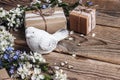 Decorative bird with apple blossom and gifts on old wooden background Royalty Free Stock Photo