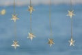 Bohemian light wires with stars hanging on blue beach background