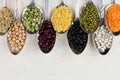 Decorative border of assortment pulses beans in spoons with copy space on white wood background. Royalty Free Stock Photo