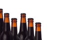 Decorative border of sealed cold dark beer bottles with porter beer and water drops isolated on white background. Royalty Free Stock Photo