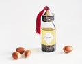 Decorative bottle with iron embossed in traditional Moroccan style with precious Moroccan argan oil and argan nuts on an