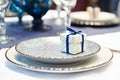 Decorative box with gift on plate of festive table Royalty Free Stock Photo