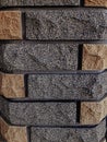 Decorative brick trim, on a pole. Gray and brown background texture. Cement joint. Chopped stone. Texture