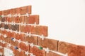 Decorative bricks with tile leveling system on white wall in room Royalty Free Stock Photo