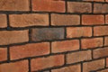 Decorative bricks on wall as background, closeup. Tiles installation process Royalty Free Stock Photo