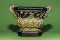 Decorative bronze cup with patterns on a green background