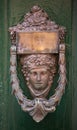 Decorative bronze door handle in the form of a beautiful woman`s head on a green painted door. Malta Royalty Free Stock Photo