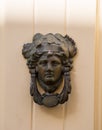 Decorative bronze traditional malttese door handle in the form of a beautiful woman`s head on a red painted door. Malta Royalty Free Stock Photo