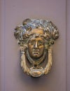 Decorative bronze traditional malttese door handle in the form of a beautiful woman`s head on a wooden door. Malta Royalty Free Stock Photo