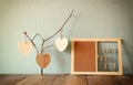 Decorative bulletin board with ropes and wooden clothespins and hanging hearts over wooden table. ready for text or mockup. retro