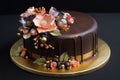decorative cake with fondant and sugar flowers, topped with chocolate ganache