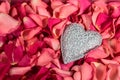 Decorative carved heart at red rose petals background