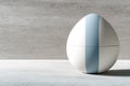 Decorative ceramic egg shaped container in minimalist design with soft blue stripe on grey surface Royalty Free Stock Photo