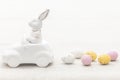 Decorative ceramic hare in a car and Easter eggs, close-up. Royalty Free Stock Photo