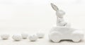 Decorative ceramic hare in a car and Easter eggs, close-up. Royalty Free Stock Photo