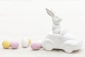 Decorative ceramic hare in a car and Easter eggs, close-up. Royalty Free Stock Photo