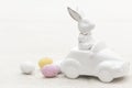Decorative ceramic hare in a car and Easter eggs, close-up. Royalty Free Stock Photo