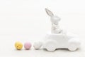 Decorative ceramic hare in a car and Easter eggs, close-up. Royalty Free Stock Photo