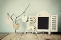 Decorative chalkboard frame and wooden hanging hearts over wooden table. ready for text or mockup. retro filtered image Royalty Free Stock Photo