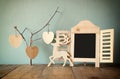 Decorative chalkboard frame and wooden hanging hearts over wooden table. ready for text or mockup. retro filtered image Royalty Free Stock Photo