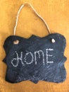 Decorative Chalkboard with HOME spelled in chalk on yellow and brown Background
