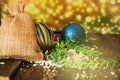 Decorative Christmas balls and canvas bag with gifts, on an old dark wooden background with a blurred shiny background