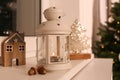 Decorative Christmas lantern with burning candle on windowsill Royalty Free Stock Photo