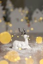 Decorative Christmas-themed figurines. Christmas deer. Christmas tree decoration. Festive decor, warm bokeh lights