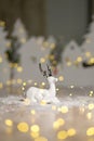 Decorative Christmas-themed figurines. Christmas deer. Christmas tree decoration. Festive decor, warm bokeh lights