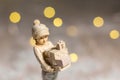 Decorative Christmas-themed figurines. Statuette of a girl holding boxes with gifts for Christmas in her hands. Christmas tree Royalty Free Stock Photo