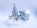 Decorative Christmas tree, ceramic pig money box and gift boxes on fluffy snow background Royalty Free Stock Photo