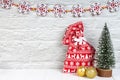 Decorative christmas tree, red gift bag and golden balls on white wooden background. Royalty Free Stock Photo