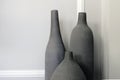 Decorative clay vases stand near a white wall. Minimalistic interior Royalty Free Stock Photo