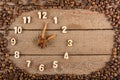 Decorative clock with wooden numerals and arrows made of cinnamon sticks, showing 2 hours, on a wooden background and a frame of c
