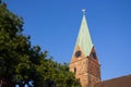 Decorative cock on steeple of ancient tower against blue sky. Weathercock on roof in Bremen, Germany. Spire of medieval church.