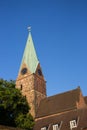 Decorative cock on steeple of ancient tower against blue sky. Weathercock on roof in Bremen, Germany. Spire of medieval church.