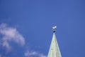 Decorative cock on steeple of ancient tower against blue sky. Weathercock on roof in Bremen, Germany. Spire of medieval church.