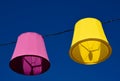 Decorative colorful canvas lamp shades supended on steel wire above public street Royalty Free Stock Photo