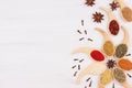 Decorative colorful christmas border of multicolored spices and anise star, clove on white wooden background, copy space. Royalty Free Stock Photo