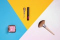 Decorative composition of colorful beauty and makeup products and tools such as powder, eyebrow pencil, lipstick and brush on a Royalty Free Stock Photo