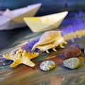 Decorative composition installation - smooth sea stones, sea salt, shells, starfish and paper boats on a blue background Royalty Free Stock Photo