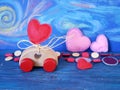 Decorative composition of a toy car and a heart made of felt on the background of pastel drawing, romantic decor on a blue wooden Royalty Free Stock Photo