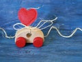 Decorative composition of a toy car and a heart made of felt on a blue background, the concept of congratulations on Valentine`s D Royalty Free Stock Photo