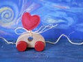 Decorative composition of a toy car and a heart made of felt on a blue background, the concept of congratulations on Valentine`s D Royalty Free Stock Photo