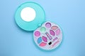 Decorative cosmetics for kids. Eye shadow palette with lipstick on light blue background, top view